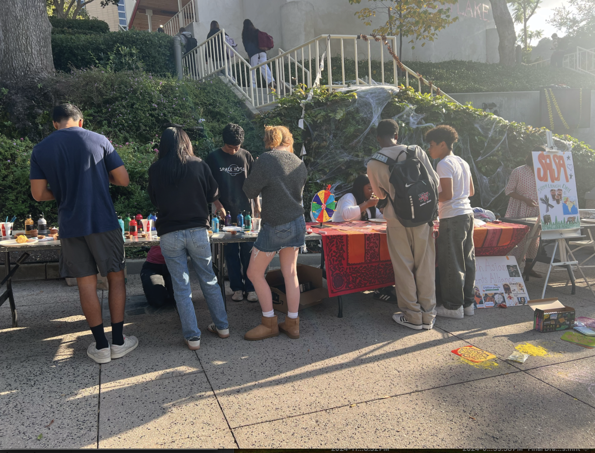 Students at the event drawing henna and painting diyas as well as enjoying samosas and beverages.